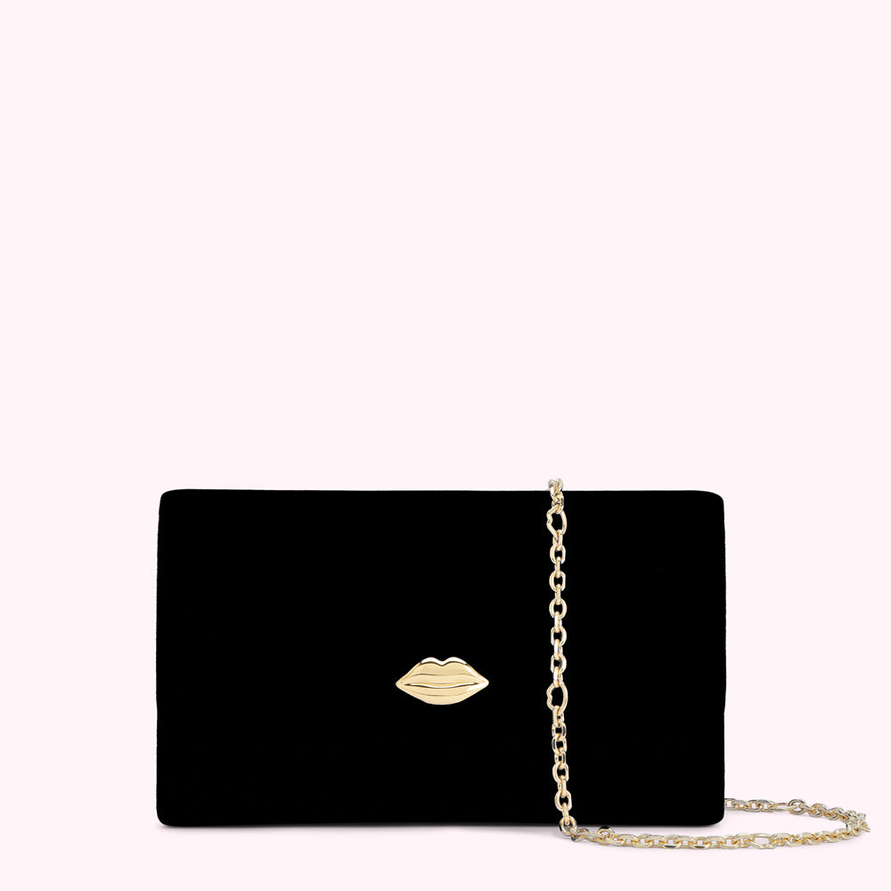Black velvet clutch with gold lip detail and chain strap.
