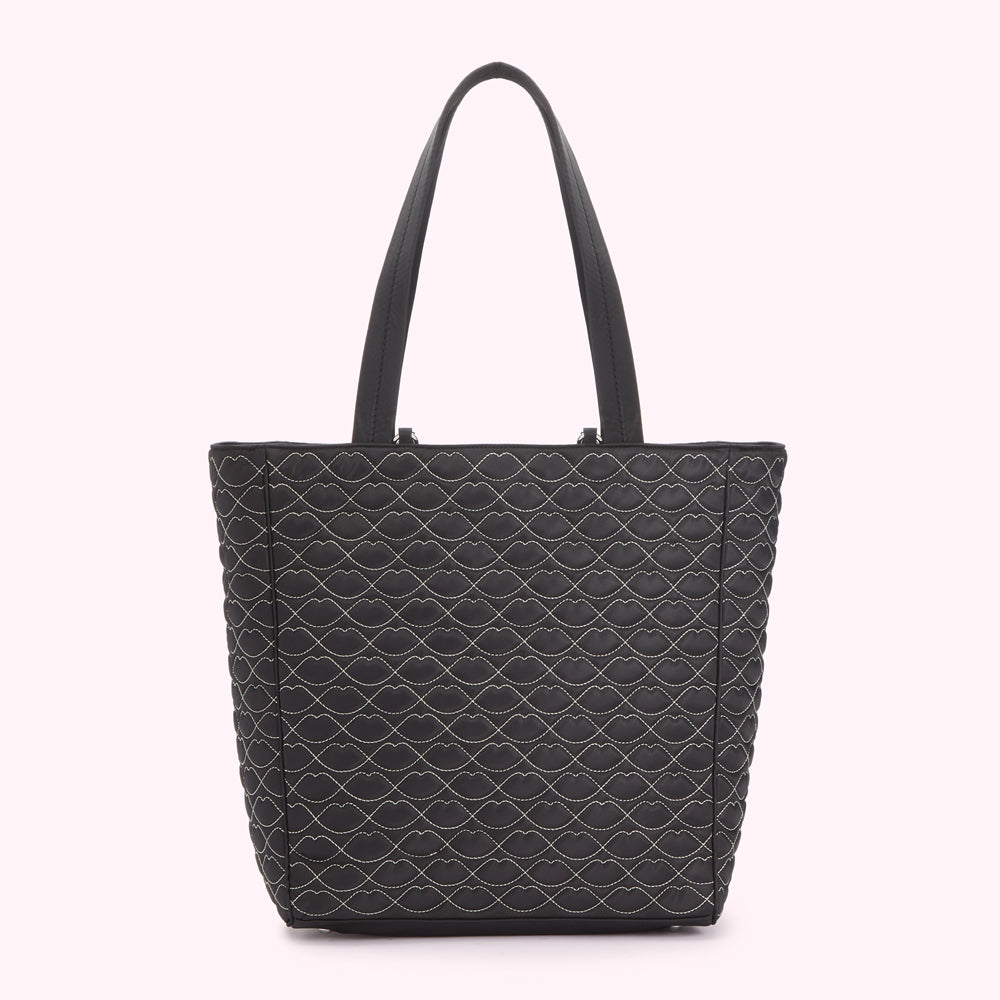 Black quilted tote bag with a lip print pattern.