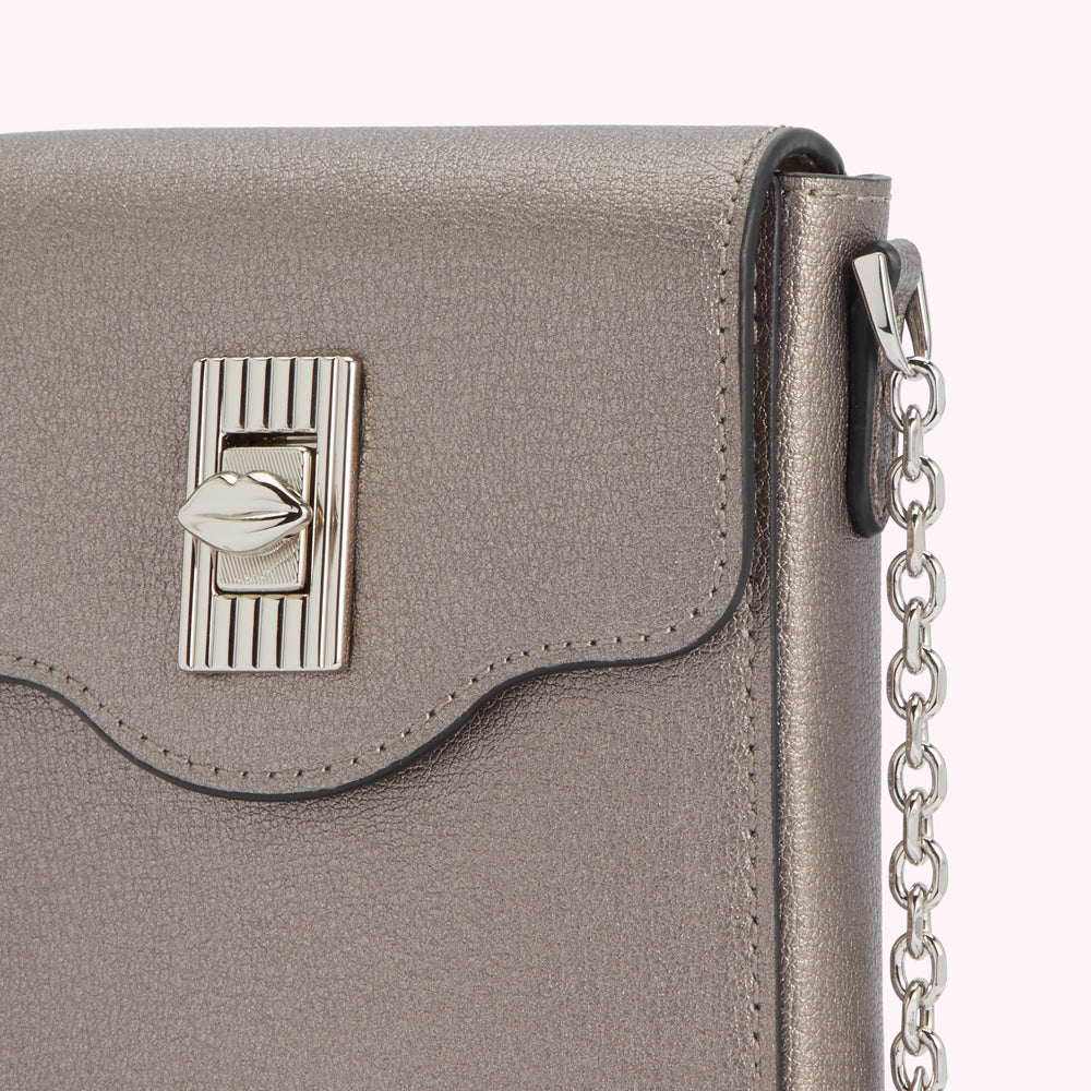Close-up of a metallic grey leather crossbody bag with a lip-shaped clasp and silver chain strap.
