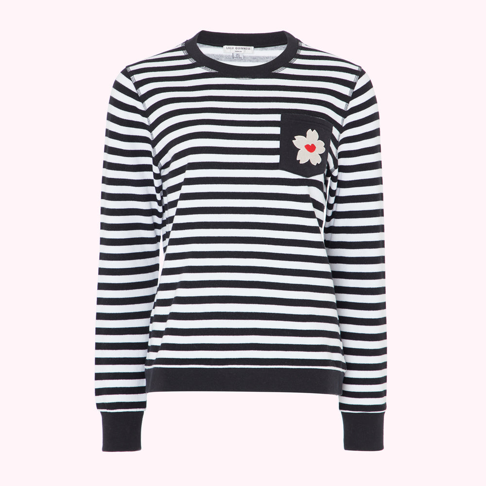Black and white striped long-sleeved top with a small flower detail on the pocket.
