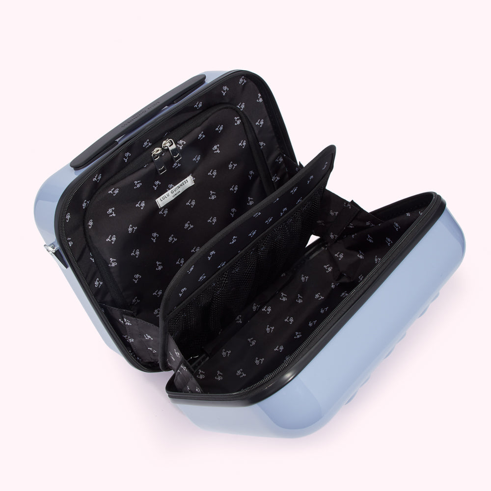Open light blue Lulu Guinness travel case with black interior showing multiple compartments and pockets.
