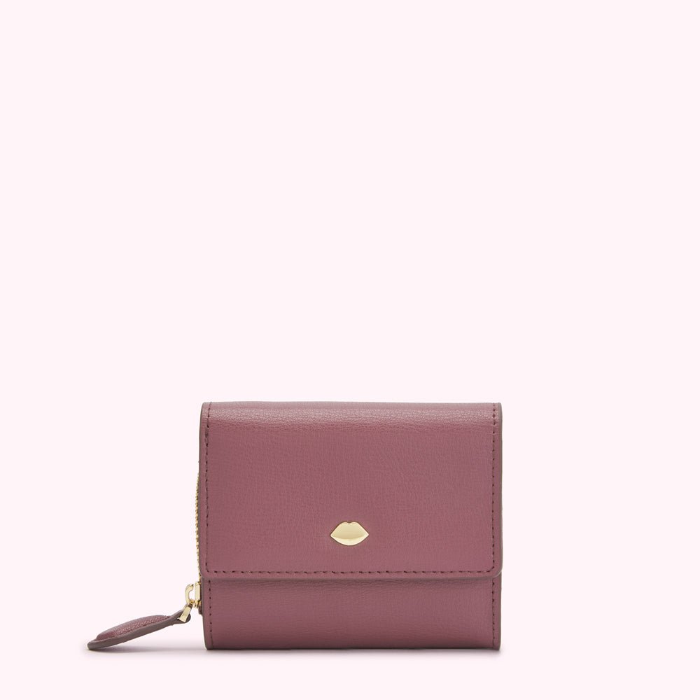 A mauve leather wallet with a gold lip-shaped logo.
