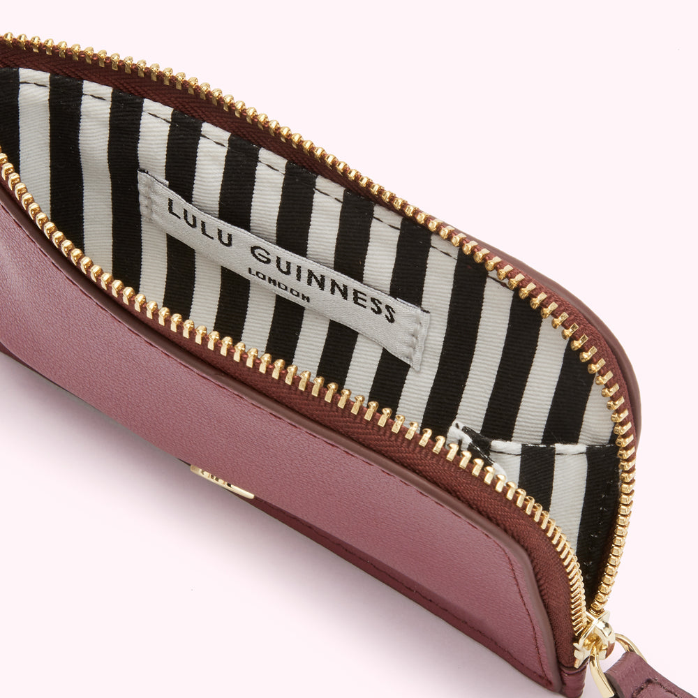 Open mauve Lulu Guinness zip-around purse with black and white striped interior.