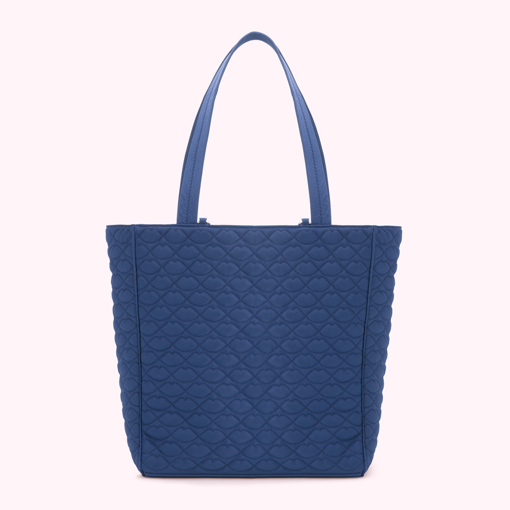 A blue quilted tote bag with a lip print pattern.
