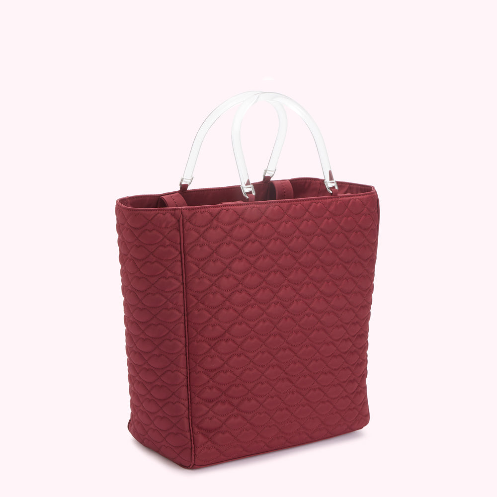 A maroon quilted tote bag with clear handles.