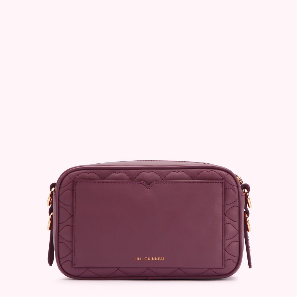 Purple quilted crossbody bag with gold hardware and Lulu Guinness logo.
