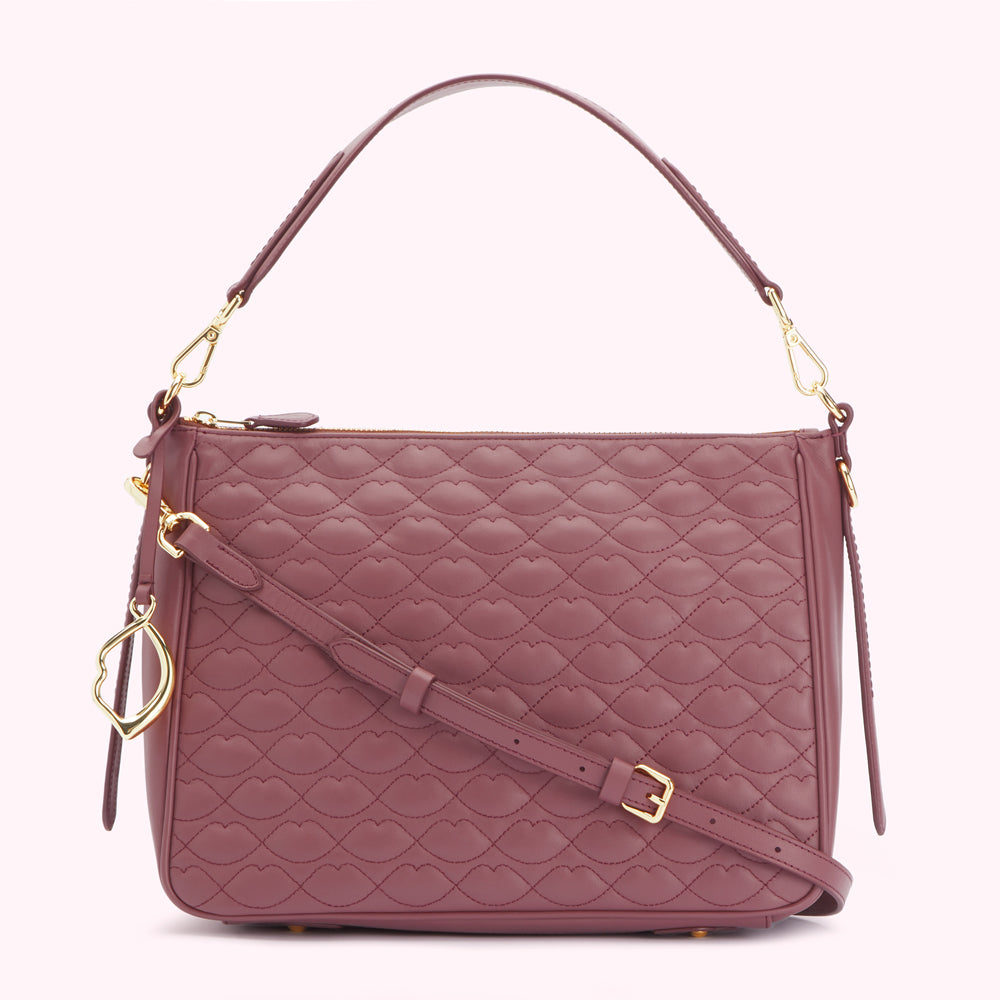 Dusty rose quilted leather shoulder bag with gold-toned hardware and lip-shaped pattern.