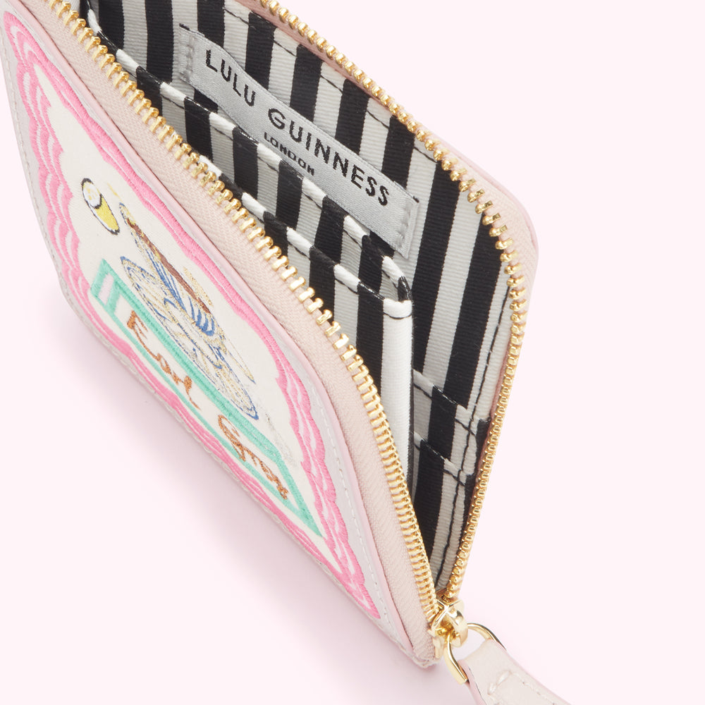 Pink Lulu Guinness zip-around purse with embroidered book design and black and white striped interior.
