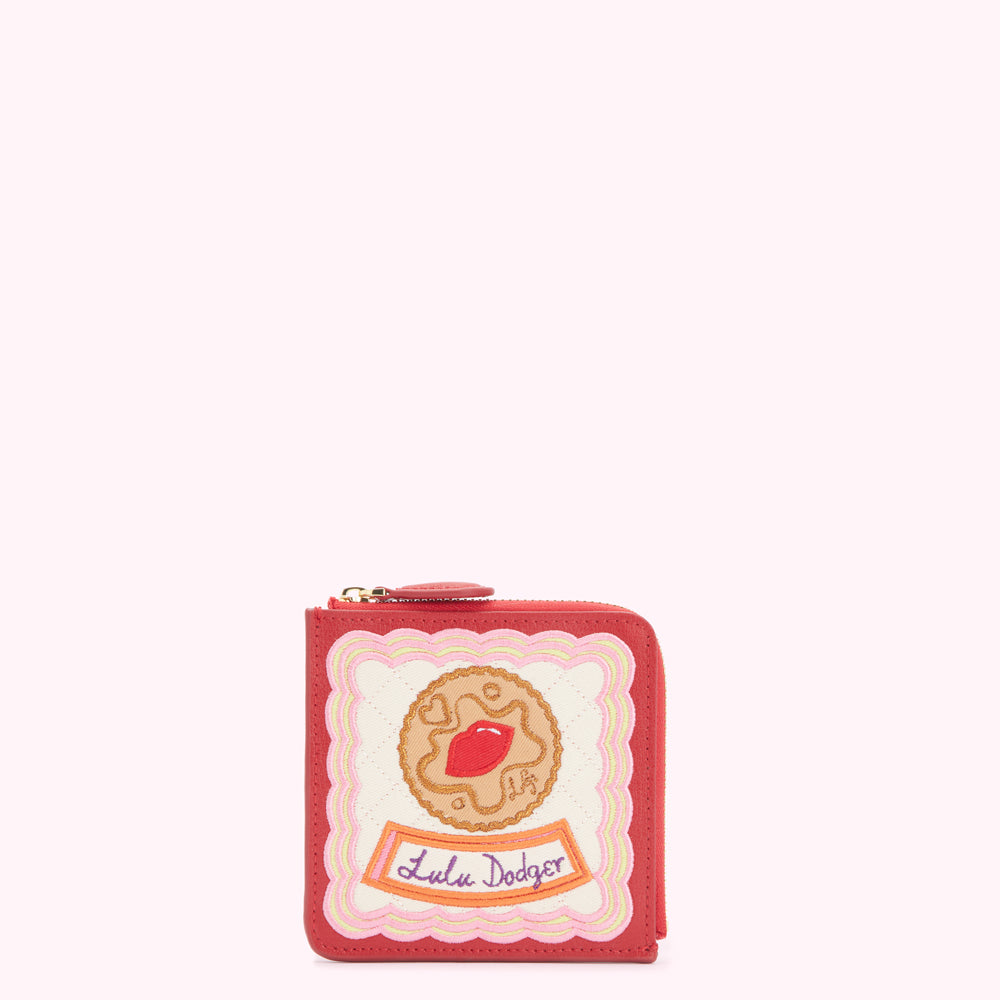 Red Lulu Guinness zip-around wallet with embroidered biscuit design.
