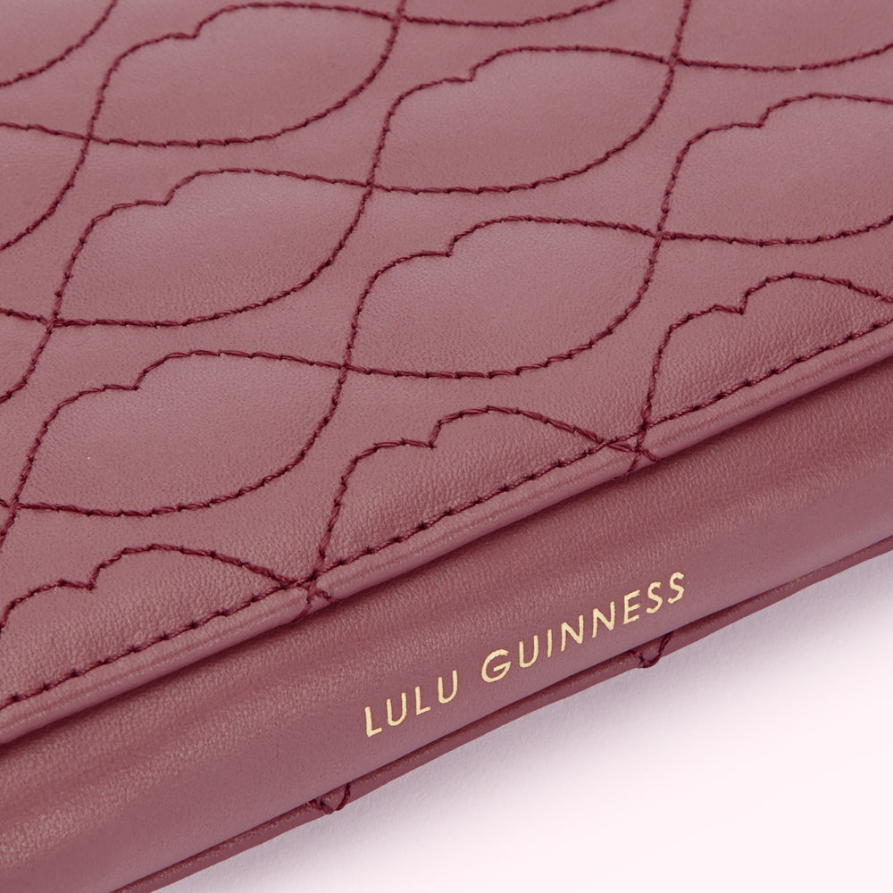 Close-up of a burgundy Lulu Guinness wallet with a quilted lip print design.
