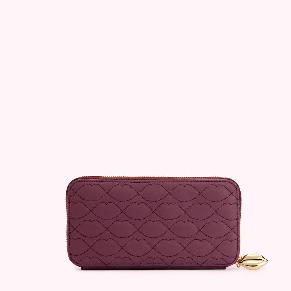 Burgundy quilted zip-around wallet with lip print and gold lip charm.
