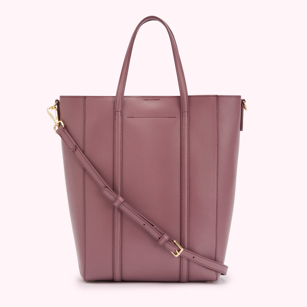 Dusty rose leather tote bag with two top handles and an adjustable crossbody strap.

