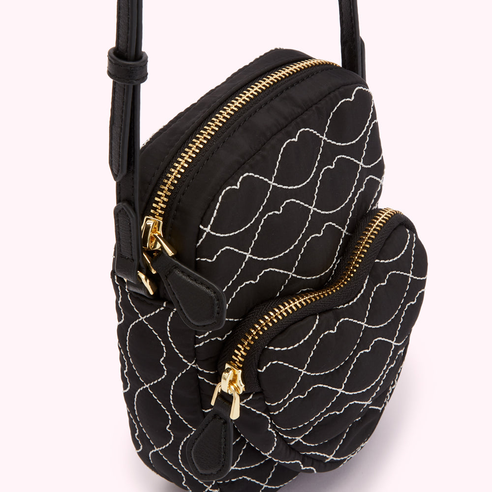 Black quilted crossbody bag with white stitching in a lip pattern, gold zippers.
