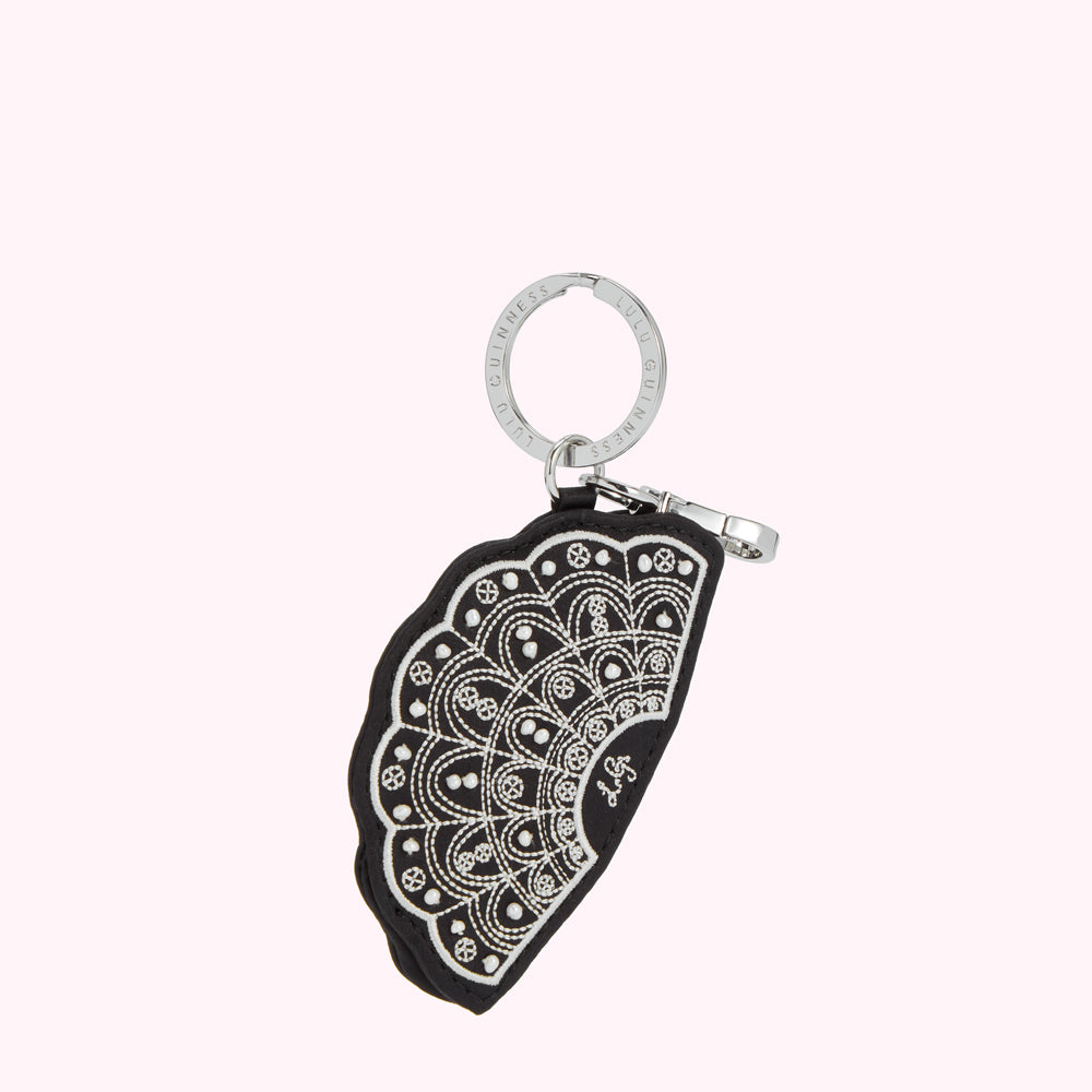 Black leather fan-shaped keyring with silver-coloured embroidery and Lulu Guinness branding.