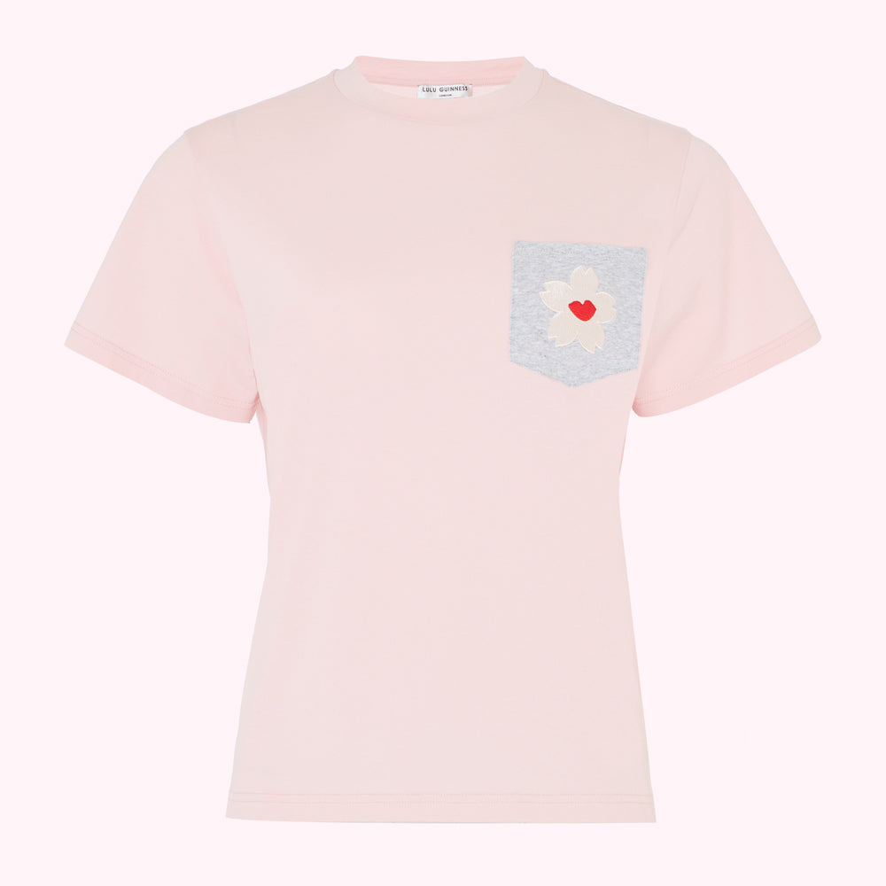 Pink t-shirt with a grey pocket and a flower appliqué©.