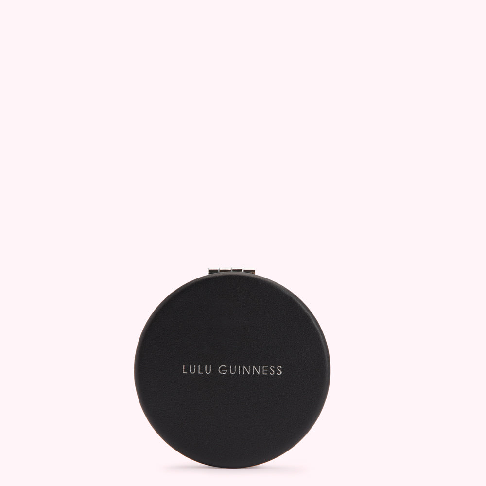 Black round compact mirror by Lulu Guinness.
