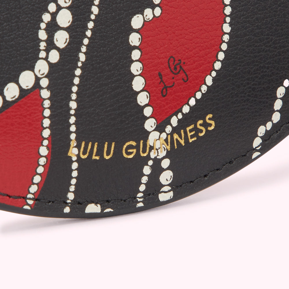 Close-up of a Lulu Guinness cardholder featuring a black background with red heart shapes outlined in white pearls and gold lettering.