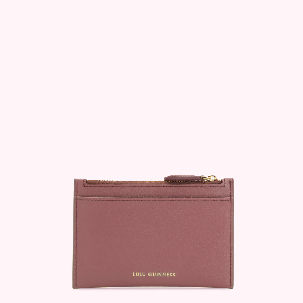 A dusty rose Lulu Guinness zip-around cardholder against a white background.
