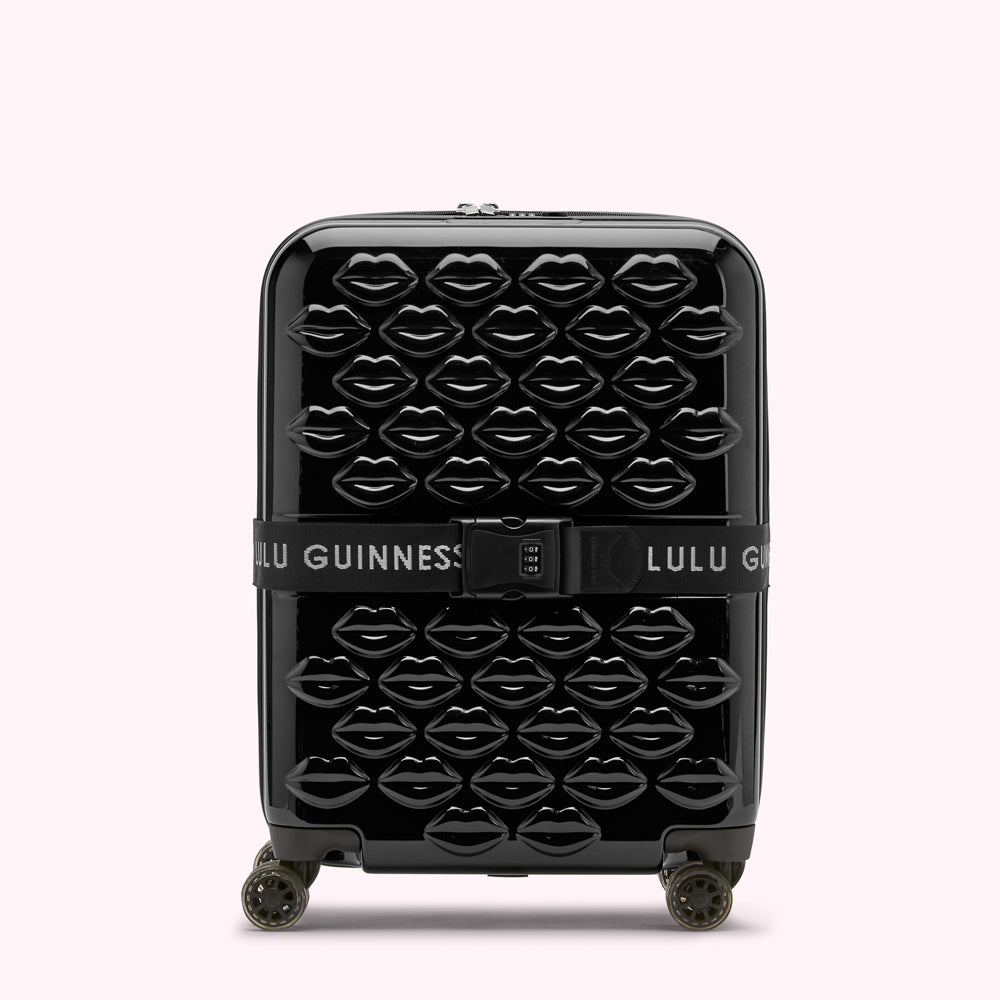 Black Lulu Guinness suitcase covered in black lips.