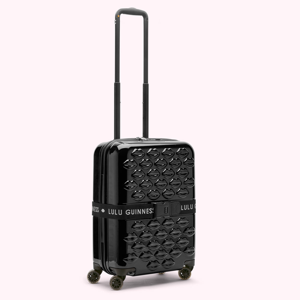 Black Lulu Guinness cabin suitcase with a lip pattern.