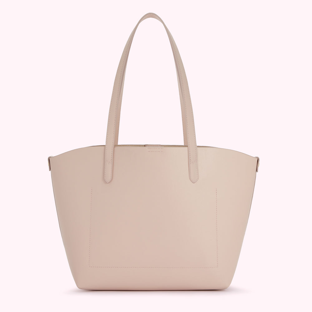 A light pink leather tote bag on a white background.