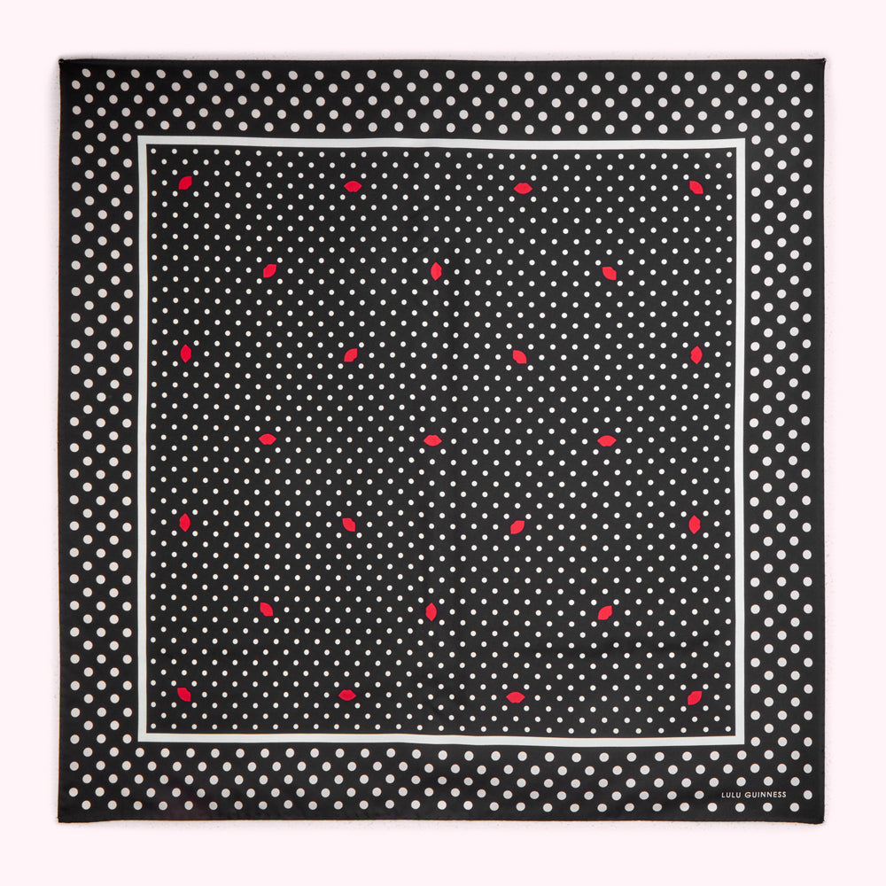 Black and white polka dot silk scarf with red lips pattern and Lulu Guinness logo.
