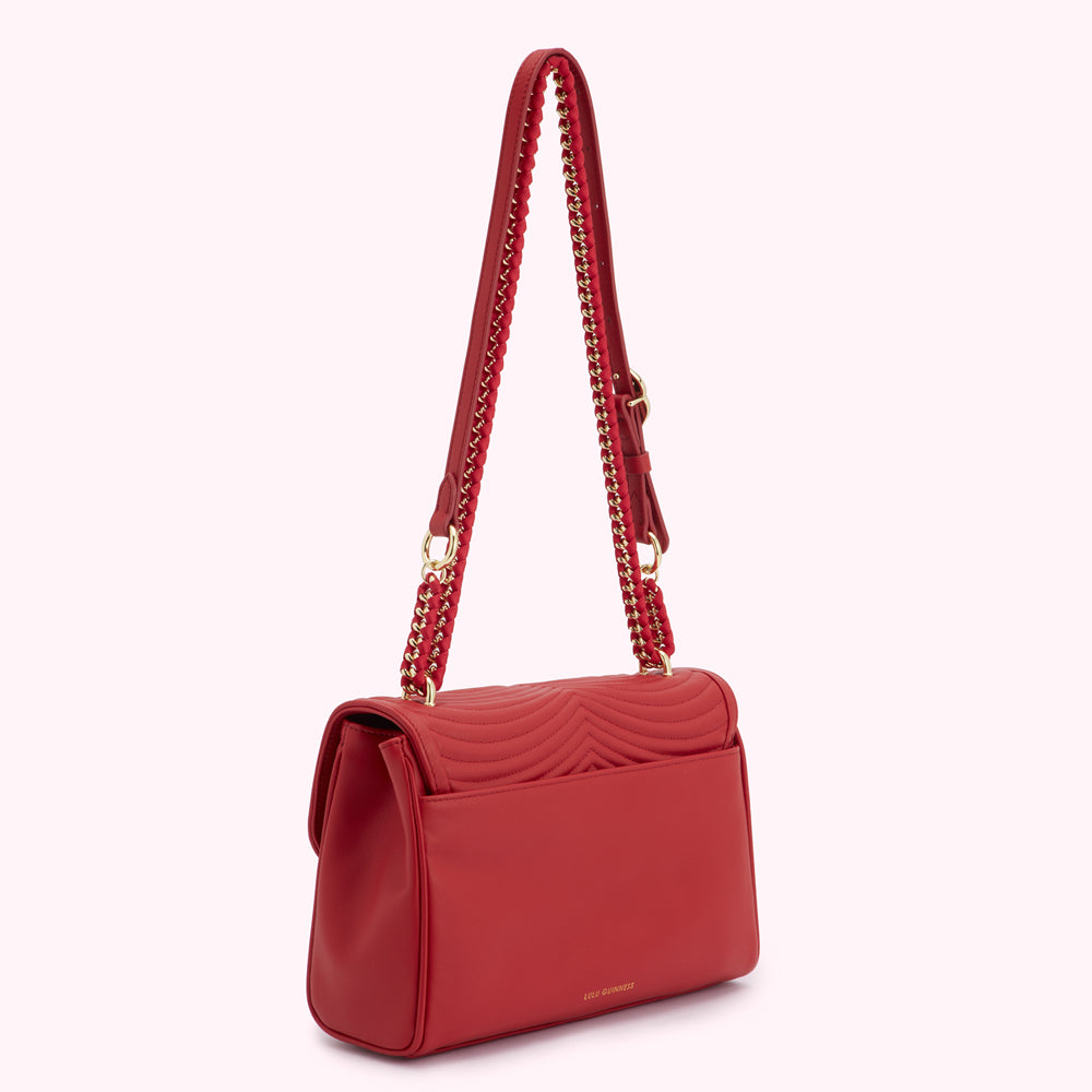 Red quilted crossbody bag with gold chain strap.
