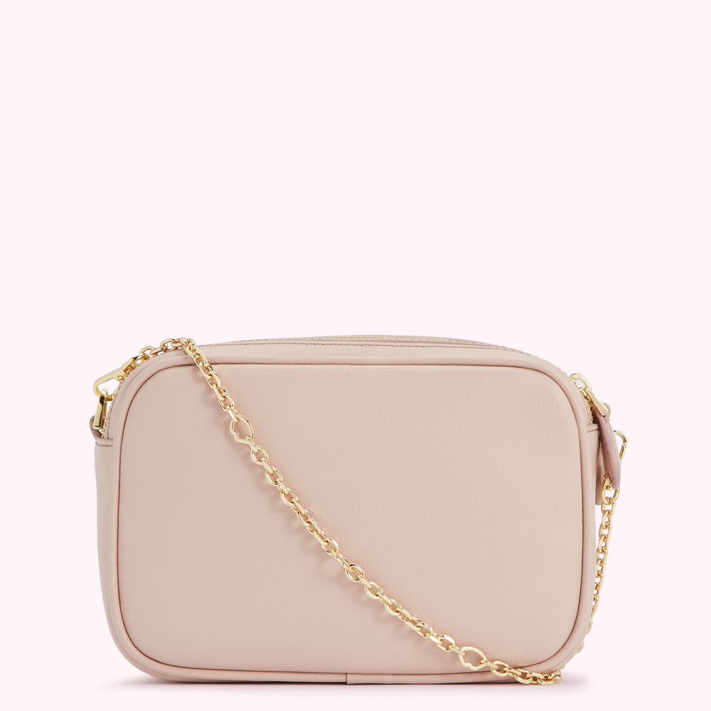A blush pink rectangular crossbody bag with a gold chain strap.
