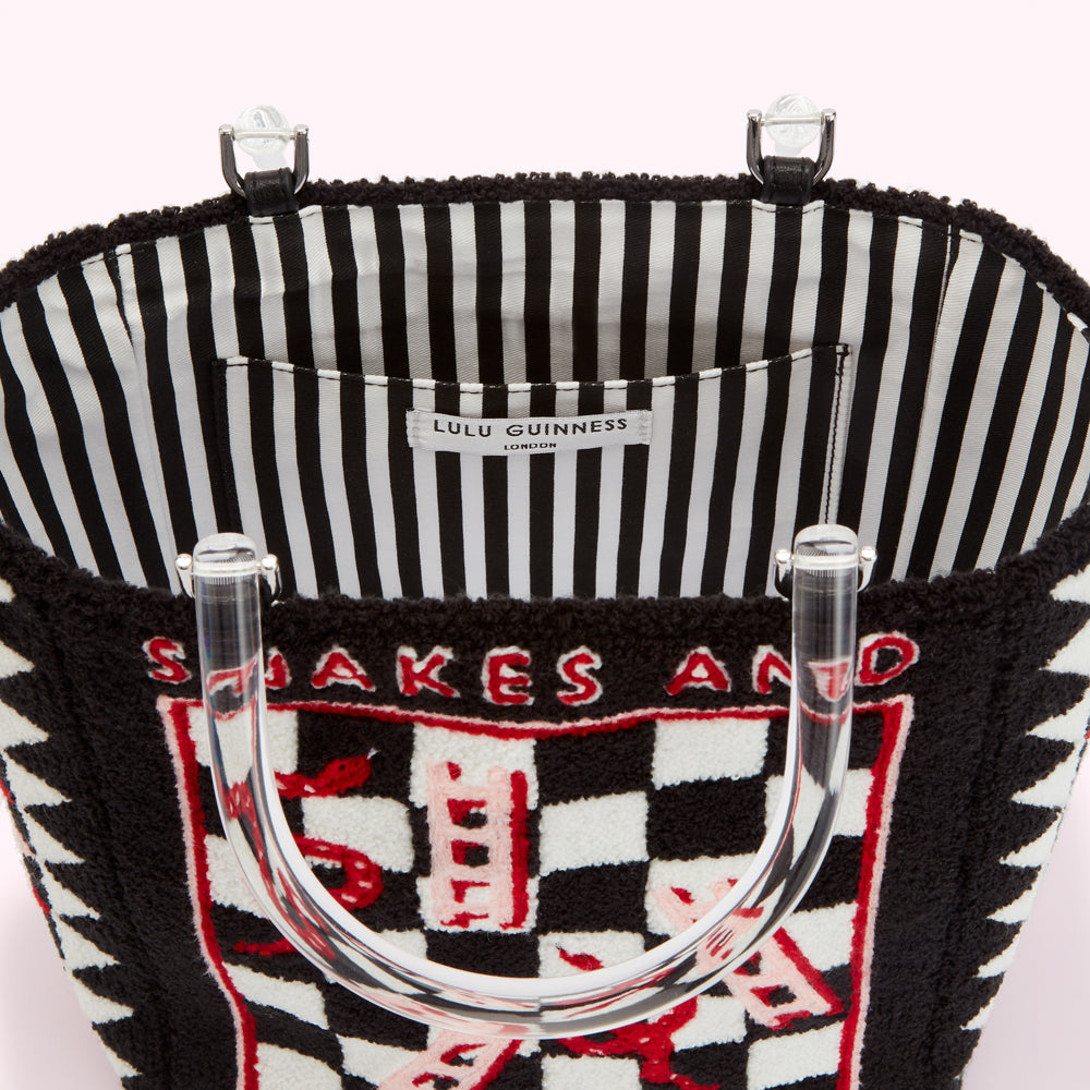 Inside view of a black Lulu Guinness Snakes and Ladders tote bag with clear Perspex handles and a black and white striped lining.