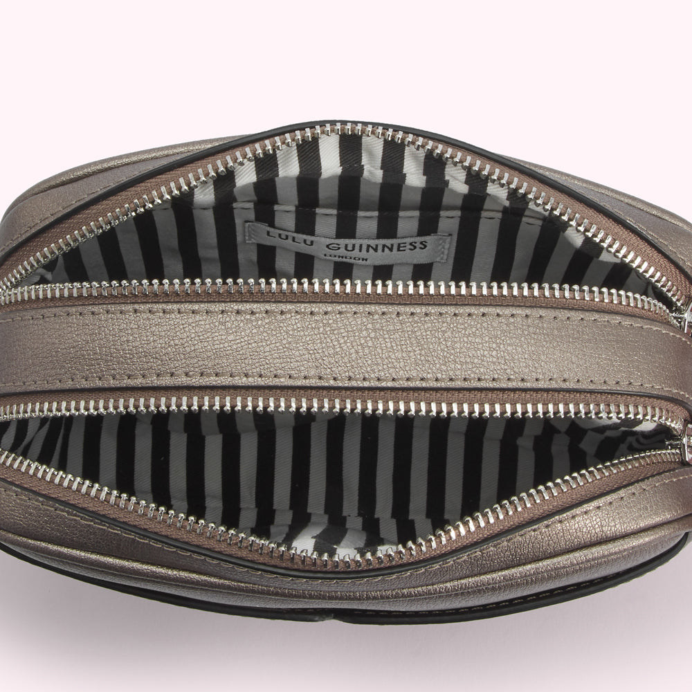 Open Lulu Guinness metallic bronze crossbody bag with black and white striped interior lining.