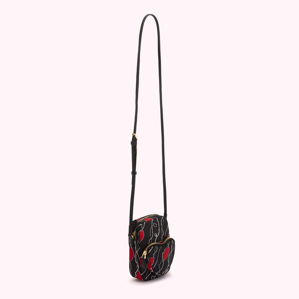Black crossbody bag with red lip print and gold zipper.
