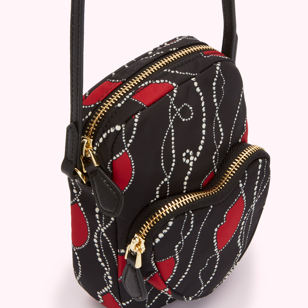 Black crossbody bag with red and white pattern.