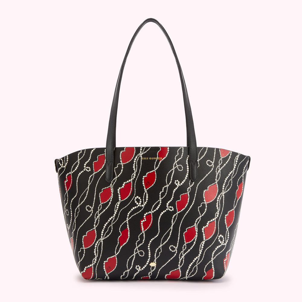 Black tote bag with red lips and pearl pattern.
