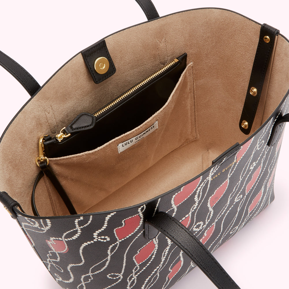 Interior of a Lulu Guinness tote bag with a beige lining and a black and red patterned exterior.