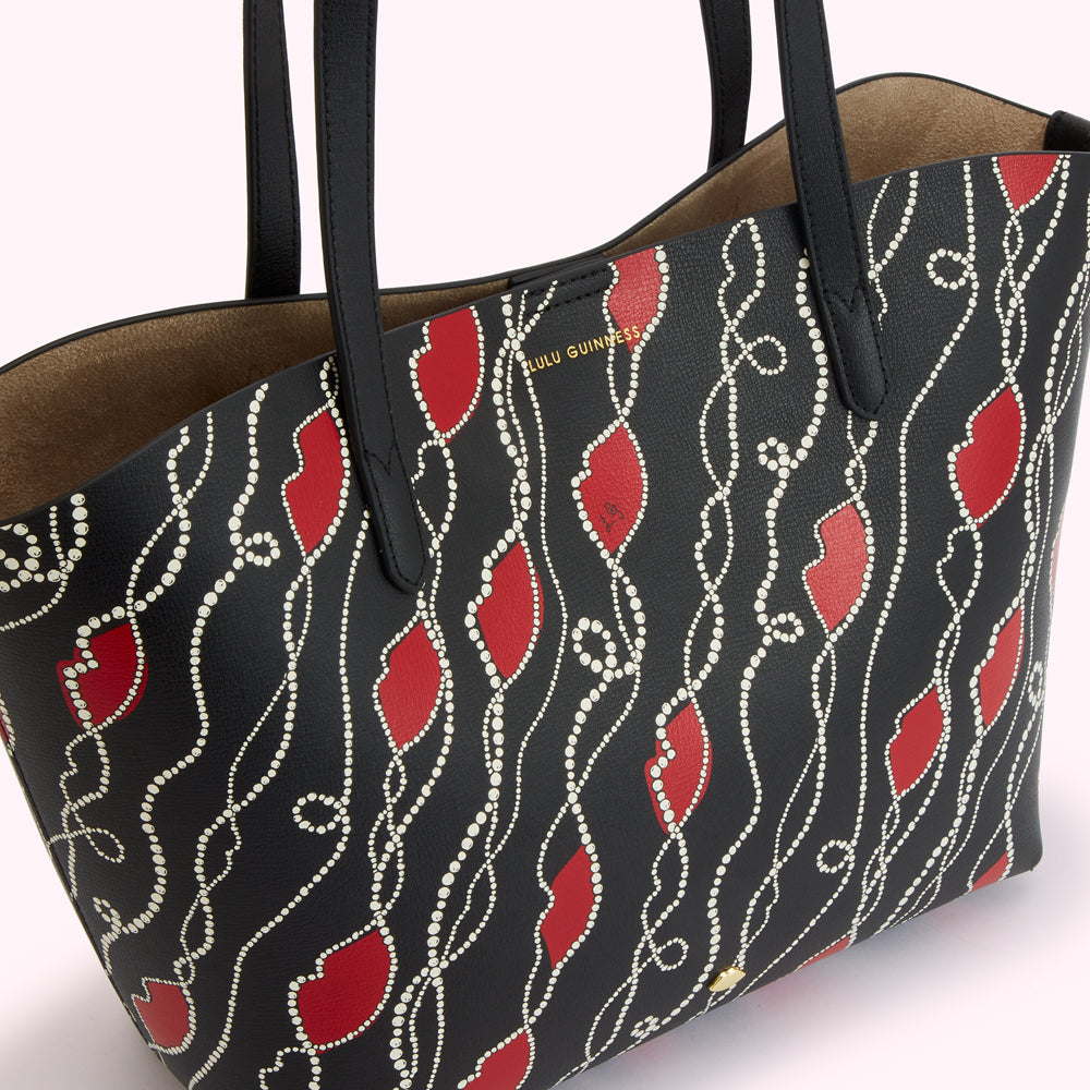 Black tote bag with red lips and white pearl design.