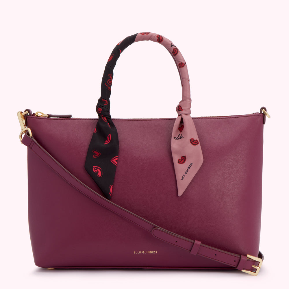 Burgundy Lulu Guinness tote bag with a removable crossbody strap and a silk scarf accent featuring a lip print.