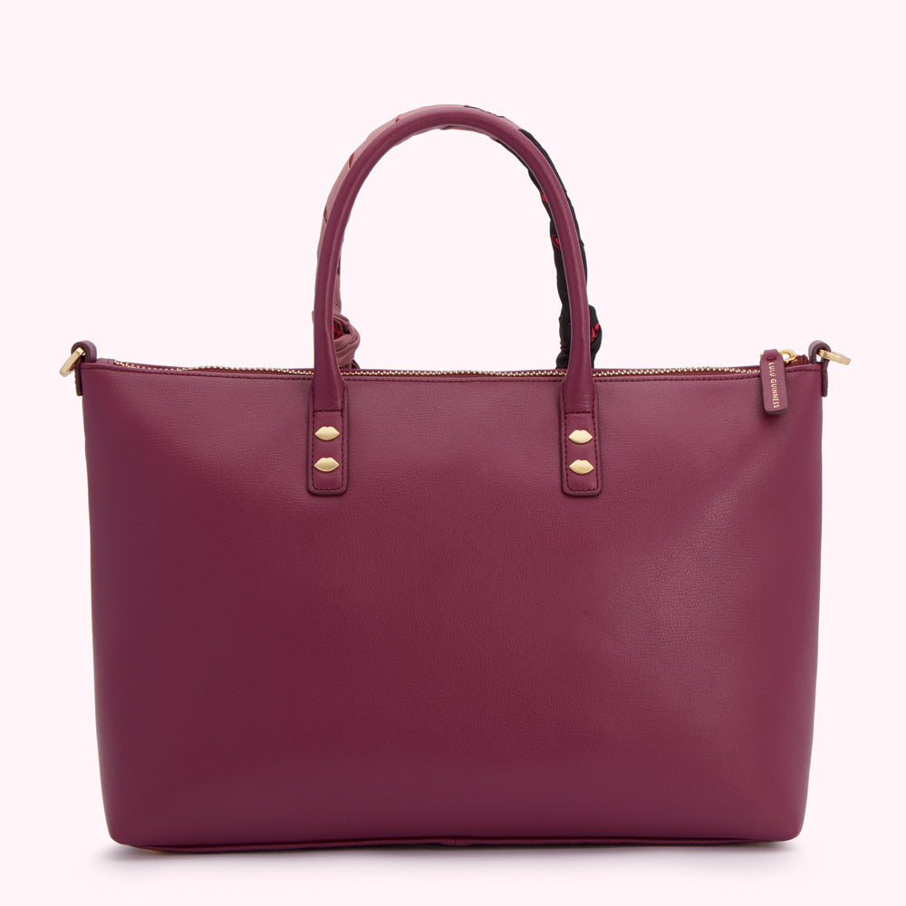 Burgundy leather tote bag with gold accents and a patterned top handle.
