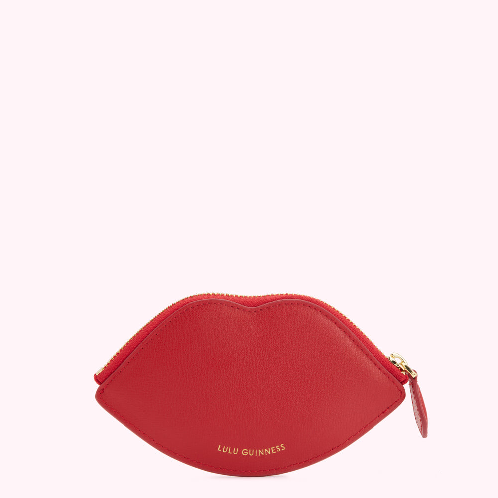 Red lip-shaped zip purse by Lulu Guinness against a white background.
