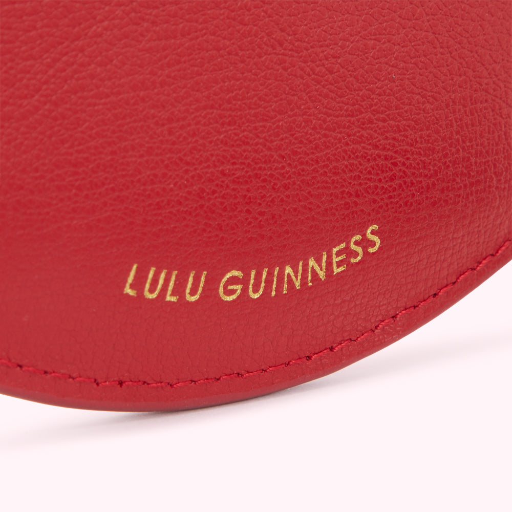 Close-up of a red leather Lulu Guinness item with gold lettering.