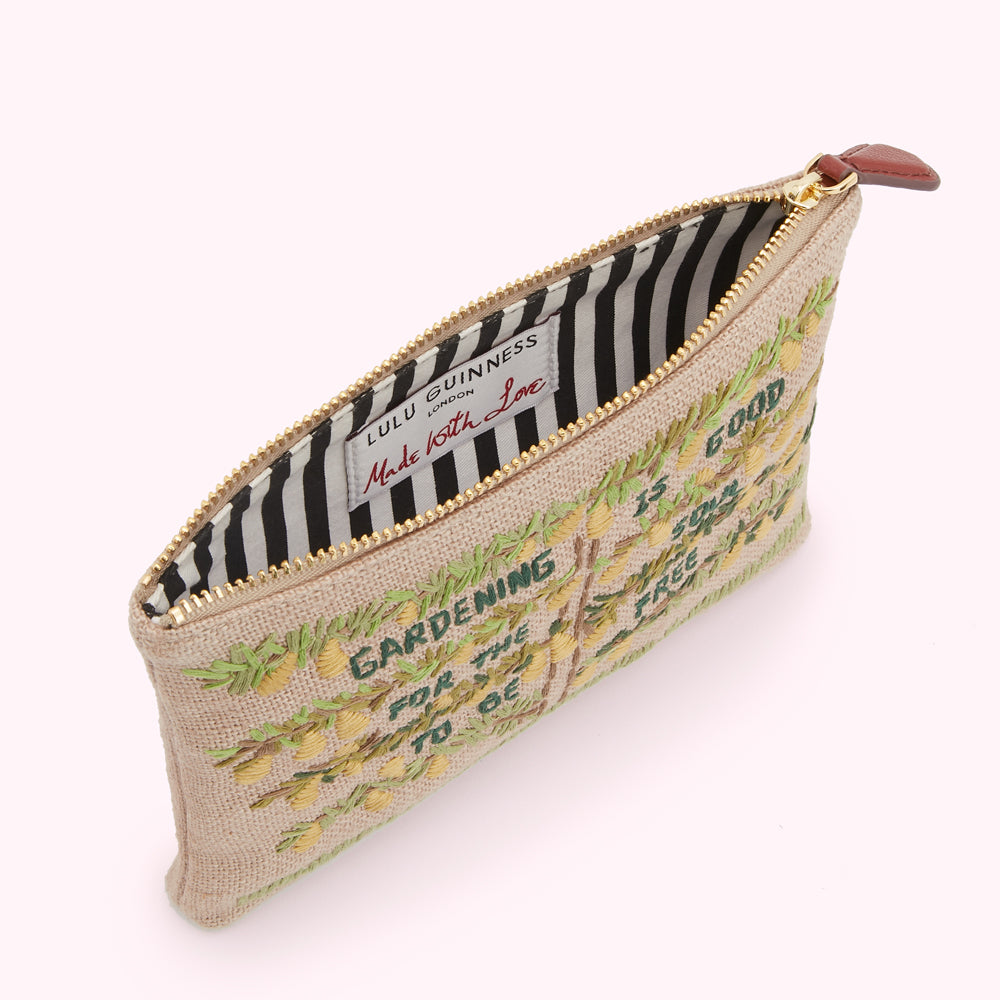 Beige zip pouch with embroidered lemons and text that reads "Gardening for the soul, is good for the tree, to be free". The inside lining is black and white striped.
