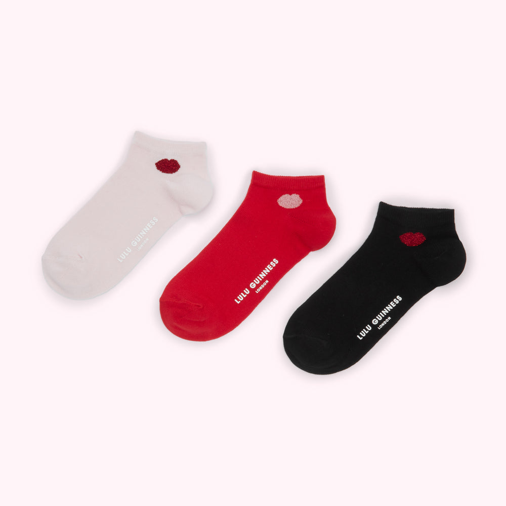 Three pairs of Lulu Guinness ankle socks in white, red, and black, each with a small lip-shaped design.
