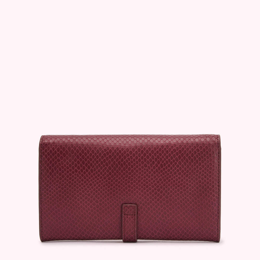 Burgundy snakeskin-textured leather wallet closed on white background.
