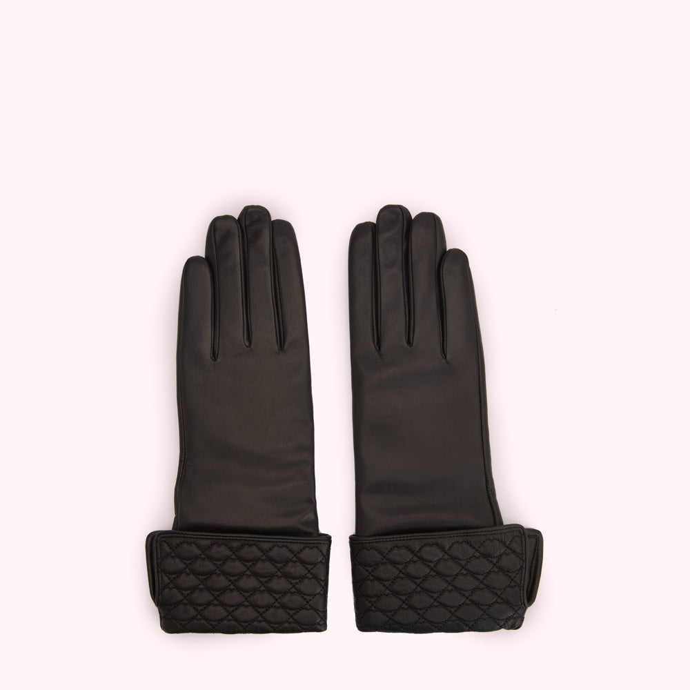 Pair of black leather gloves with quilted cuffs against a white background.

