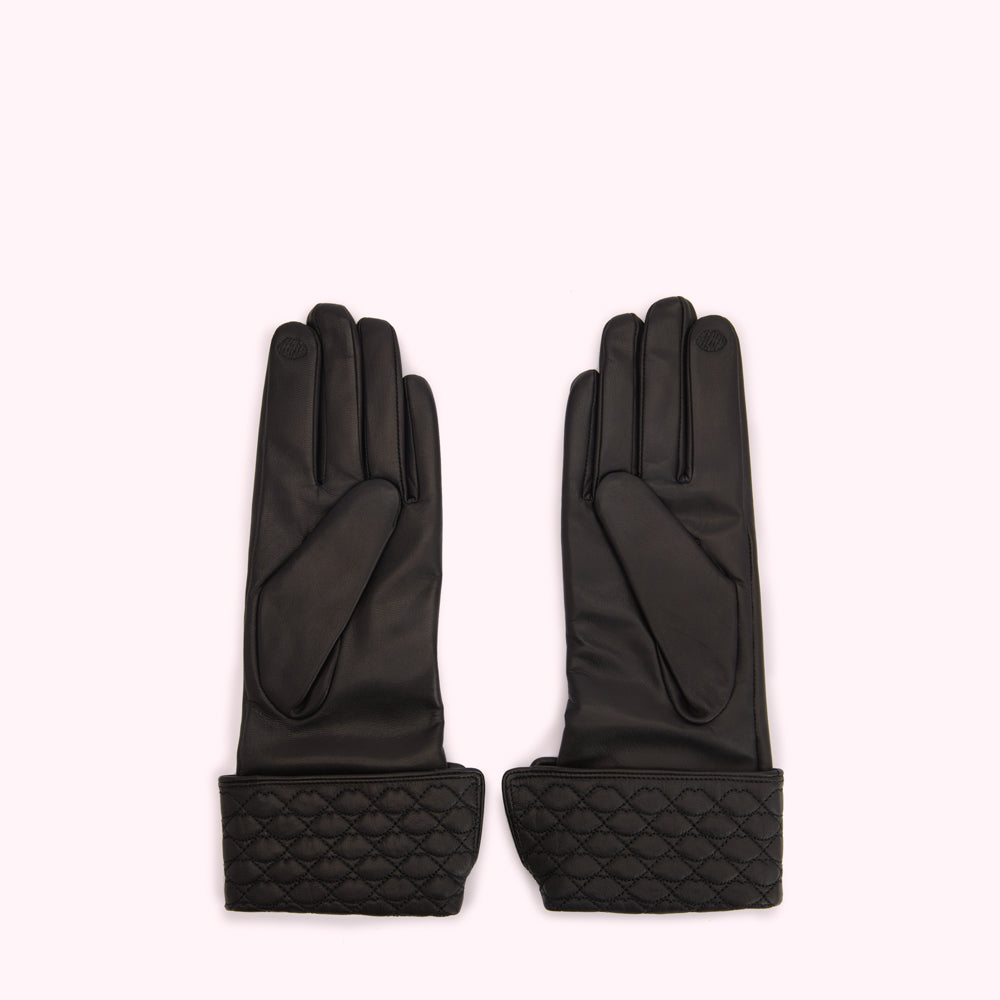 Pair of black leather gloves with quilted cuffs against a white background.
