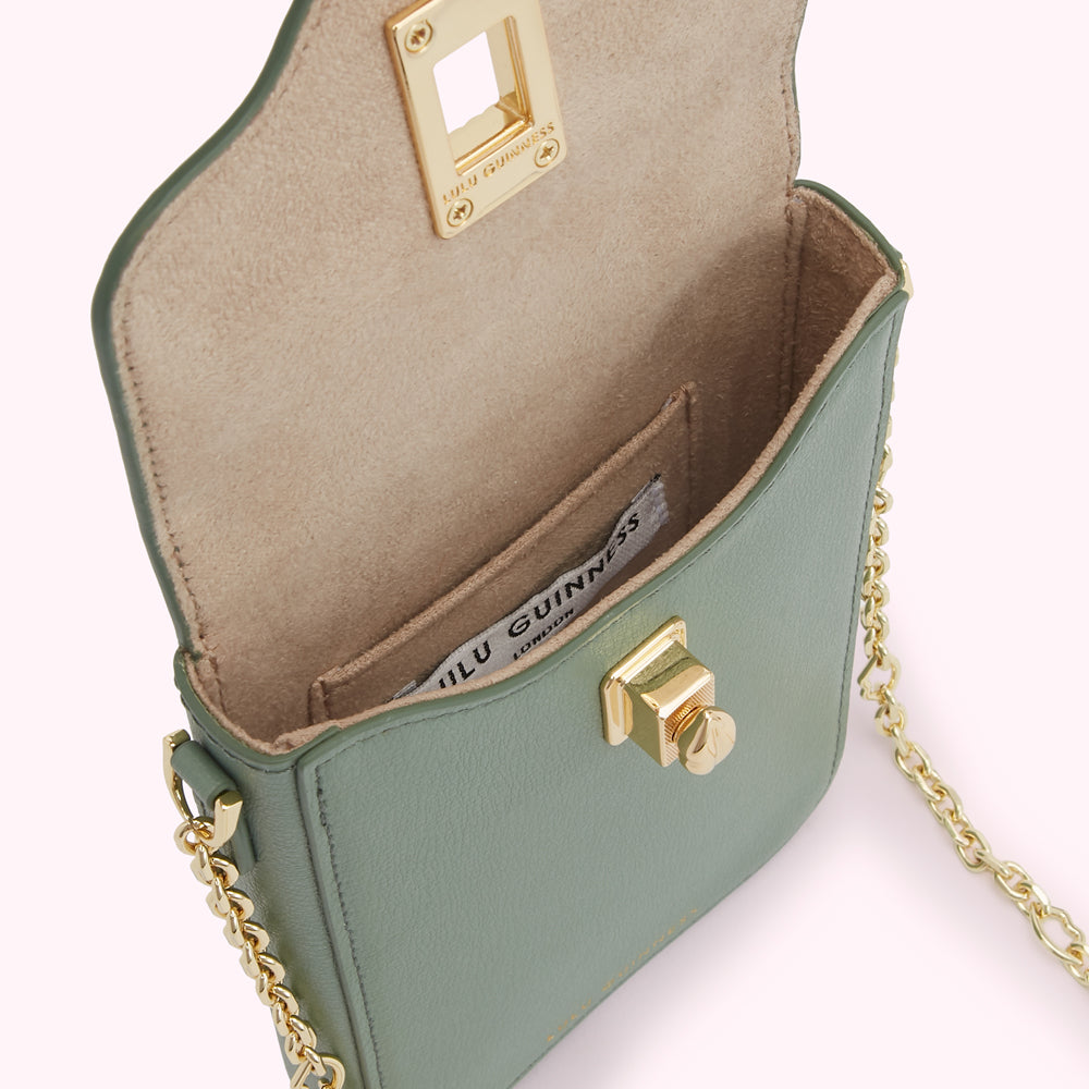 Sage green leather Lulu Guinness crossbody bag with gold hardware, shown open to reveal beige interior and brand label.

