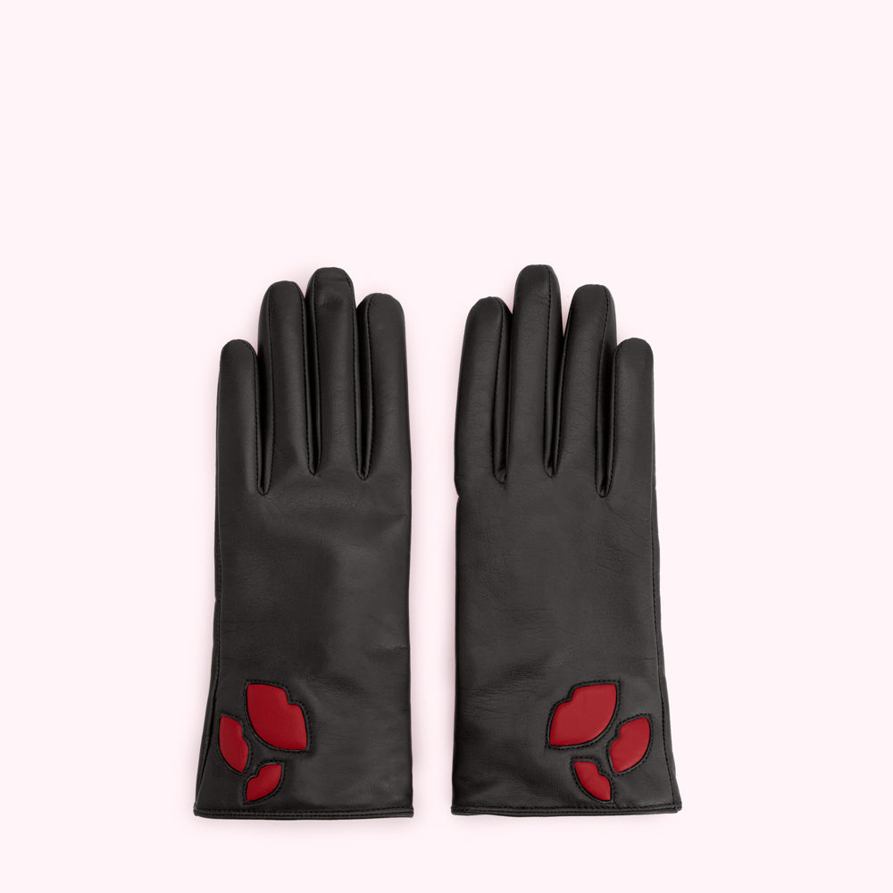 Pair of black leather gloves with red lip detail against a white background.
