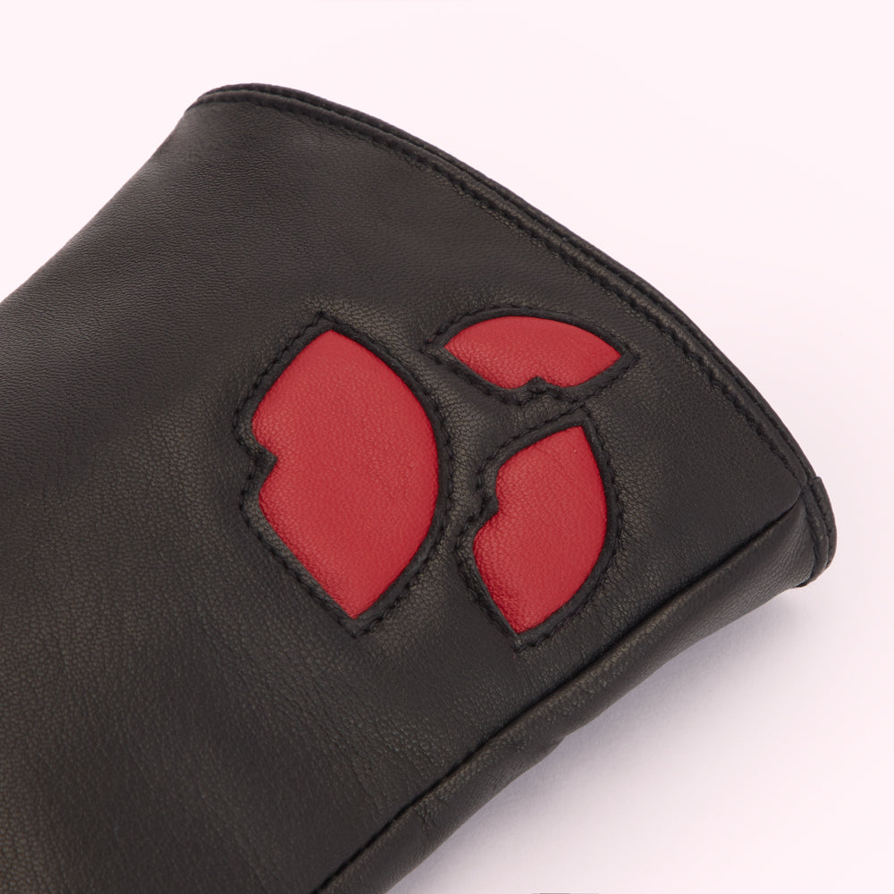 Close-up of a black leather glove with a red floral design.
