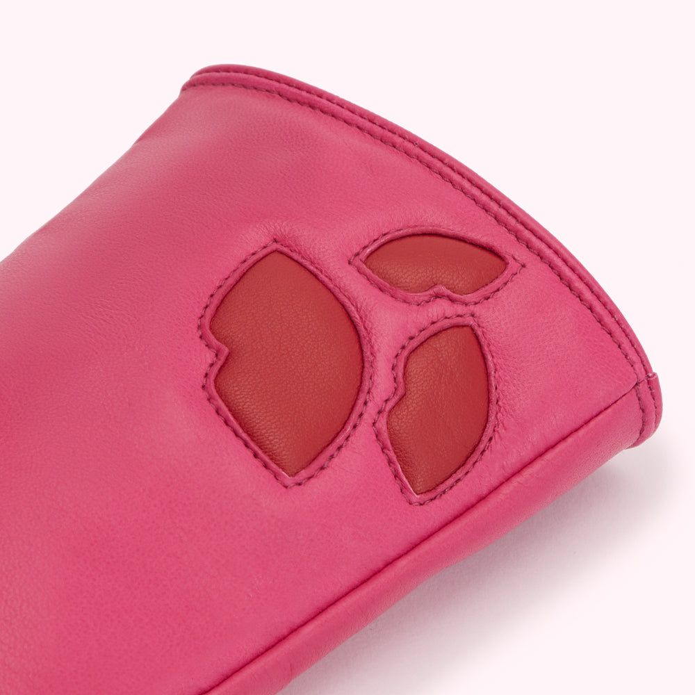 Close-up of a pink leather glove with a red leather flower design.
