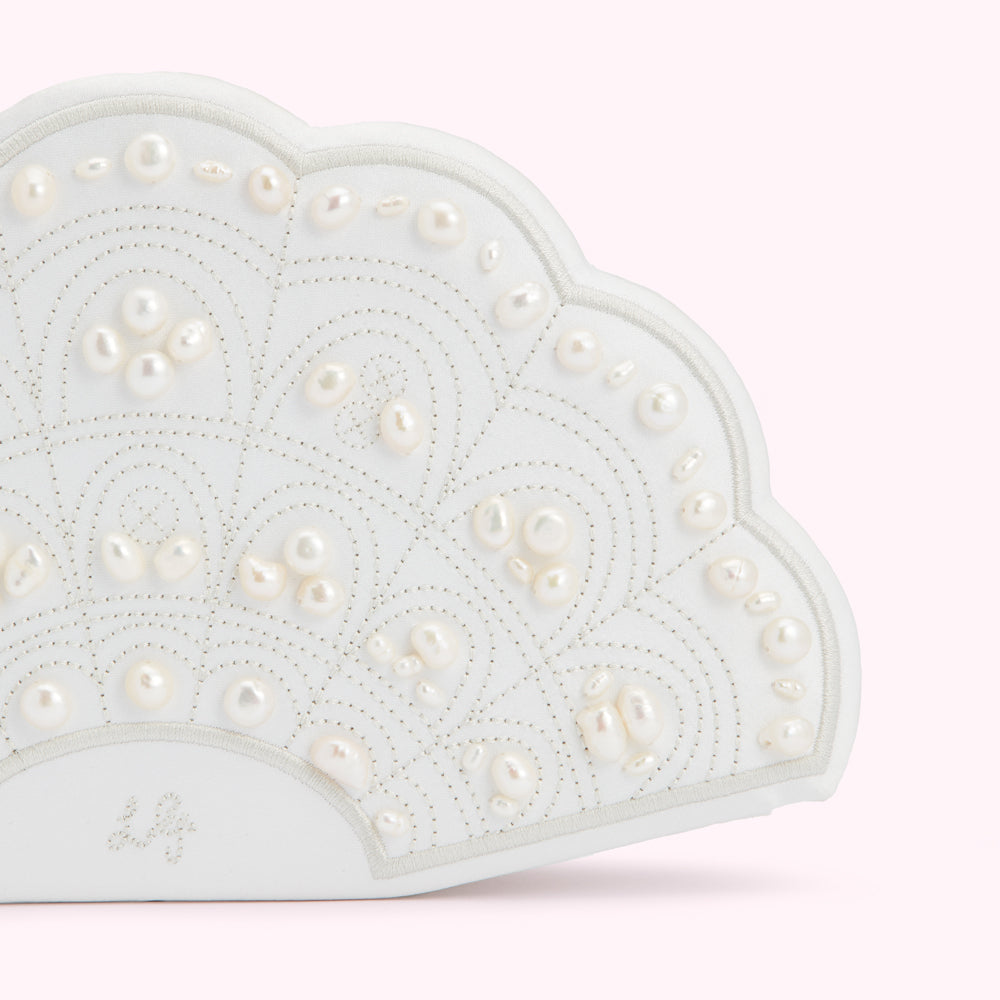 White fan-shaped clutch adorned with pearls.