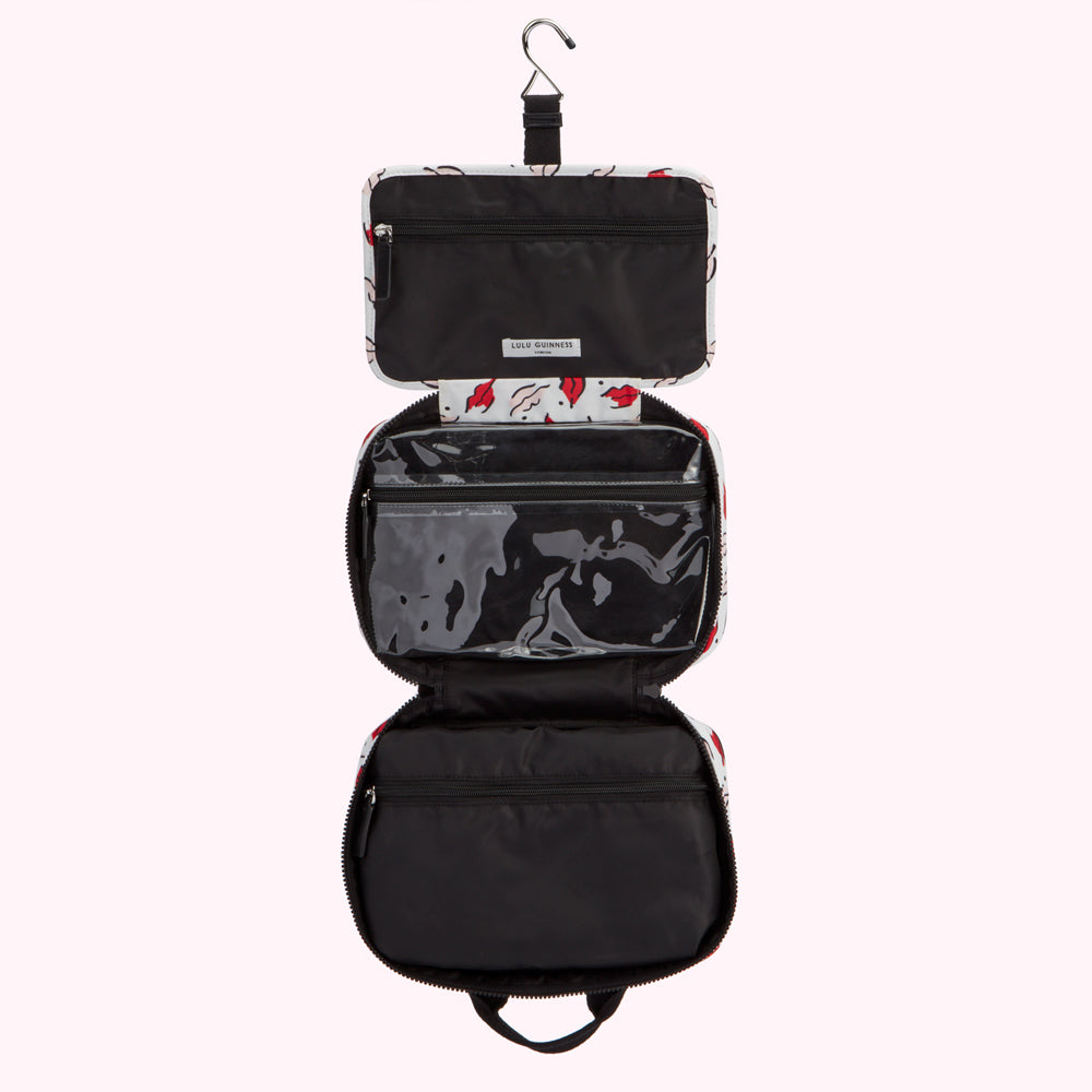 Open Lulu Guinness hanging travel makeup case with red lips print.